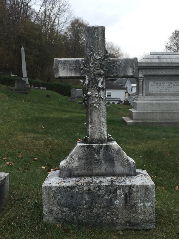 The front of Elizabeth Wilkinson’s gave has her initials E. W. M. on it along with the intricate flowers that tangle all around it. When she and her husband was alive the attend church at the Baptist church.<br />
Dudley, Lara Maria. "Elizabeth Wilkinson's Grave Front." Digital image. Flickr. Accessed December 5, 2017. https://www.flickr.com/photos/140946061@N06/37689271234/in/dateposted-public/
